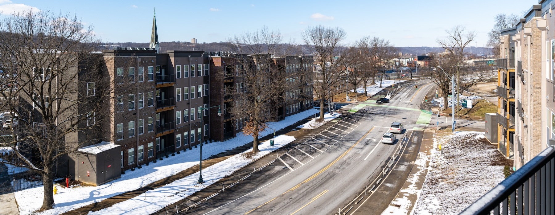 a road with snow on the side and buildings on the side