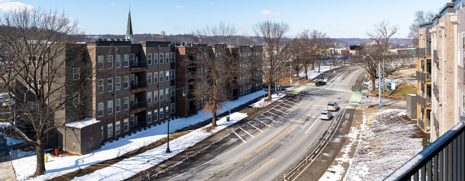 a road with snow on the side and buildings on the side